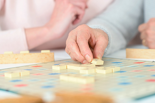 Older couple playing a game of scrabble and appreciating their time spent together